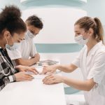 Profissionais de saúde atendem pacientes no balcão de uma unidade médica.