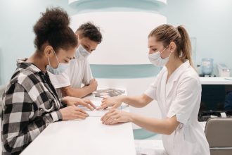 Profissionais de saúde atendem pacientes no balcão de uma unidade médica.